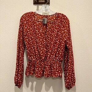 Deep v-neck blood orange floral blouse. A little big for me (5’4” 125lbs)